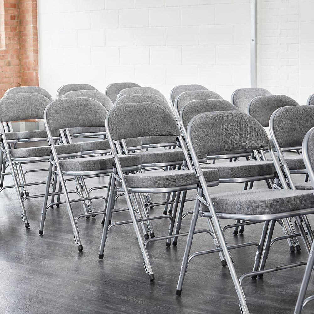 Rows of grey Comfort Deluxe padded folding chairs in a hall.