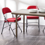 Red Comfort Deluxe padded folding chairs around a folding table.