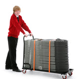 School boy pushing folding chair trolley fully loaded with plastic folding chairs.