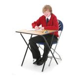 School boy sitting at a folding exam desk poised to write on exam paper. 