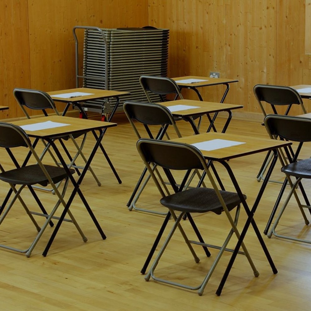 Plastic Folding Chairs and Exam Desks in School Hall.