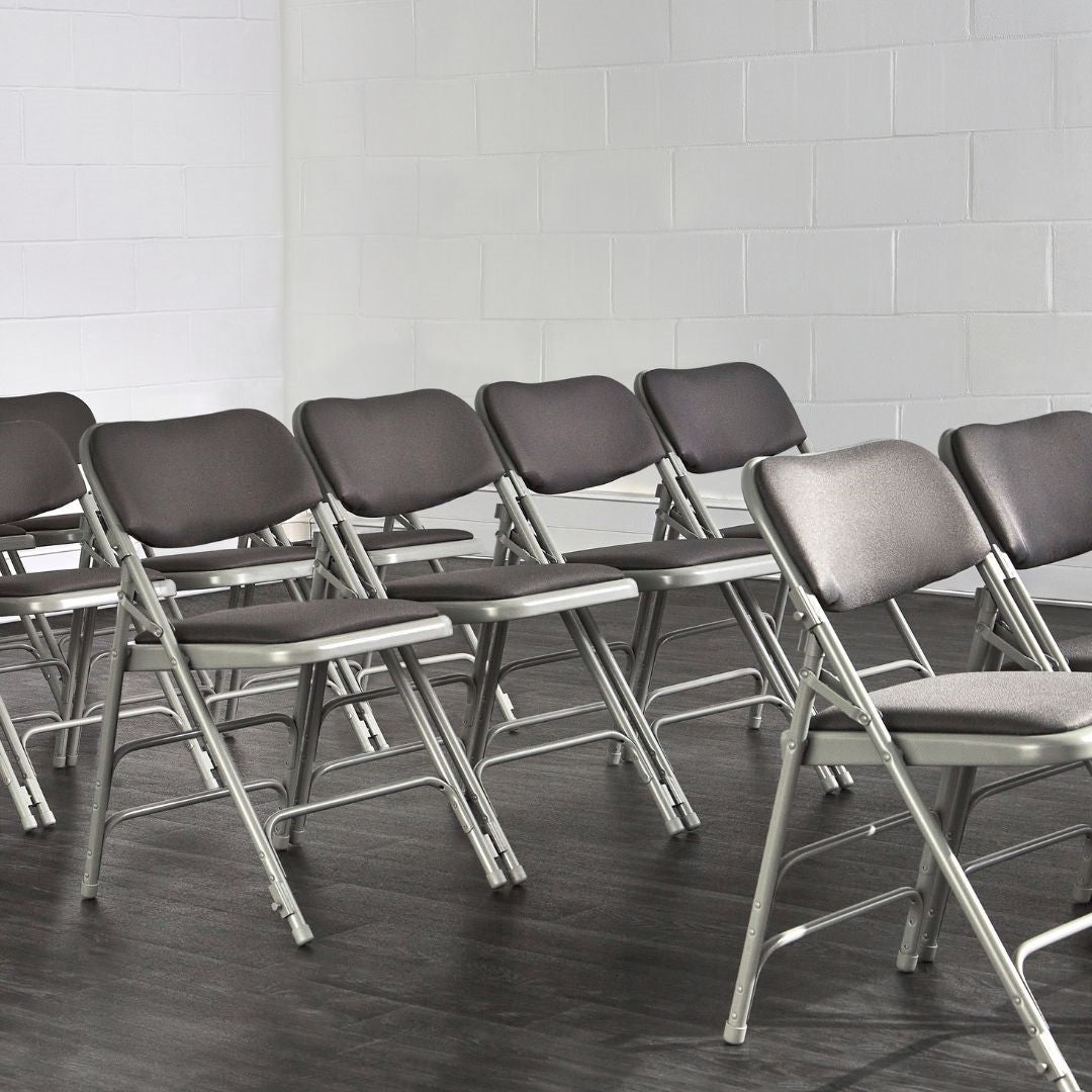 Rows of grey Comfort padded folding chairs in modern hall setting.