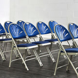 Rows of blue padded folding chairs in meeting room.