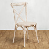 Wooden chair with a woven seat on a wooden floor against a white wall - front angle.
