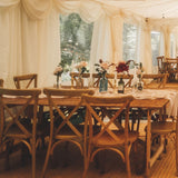 Event setup with rustic farm table and crossback chairs