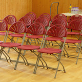 Rows of red plastic folding chairs set up in community hall.