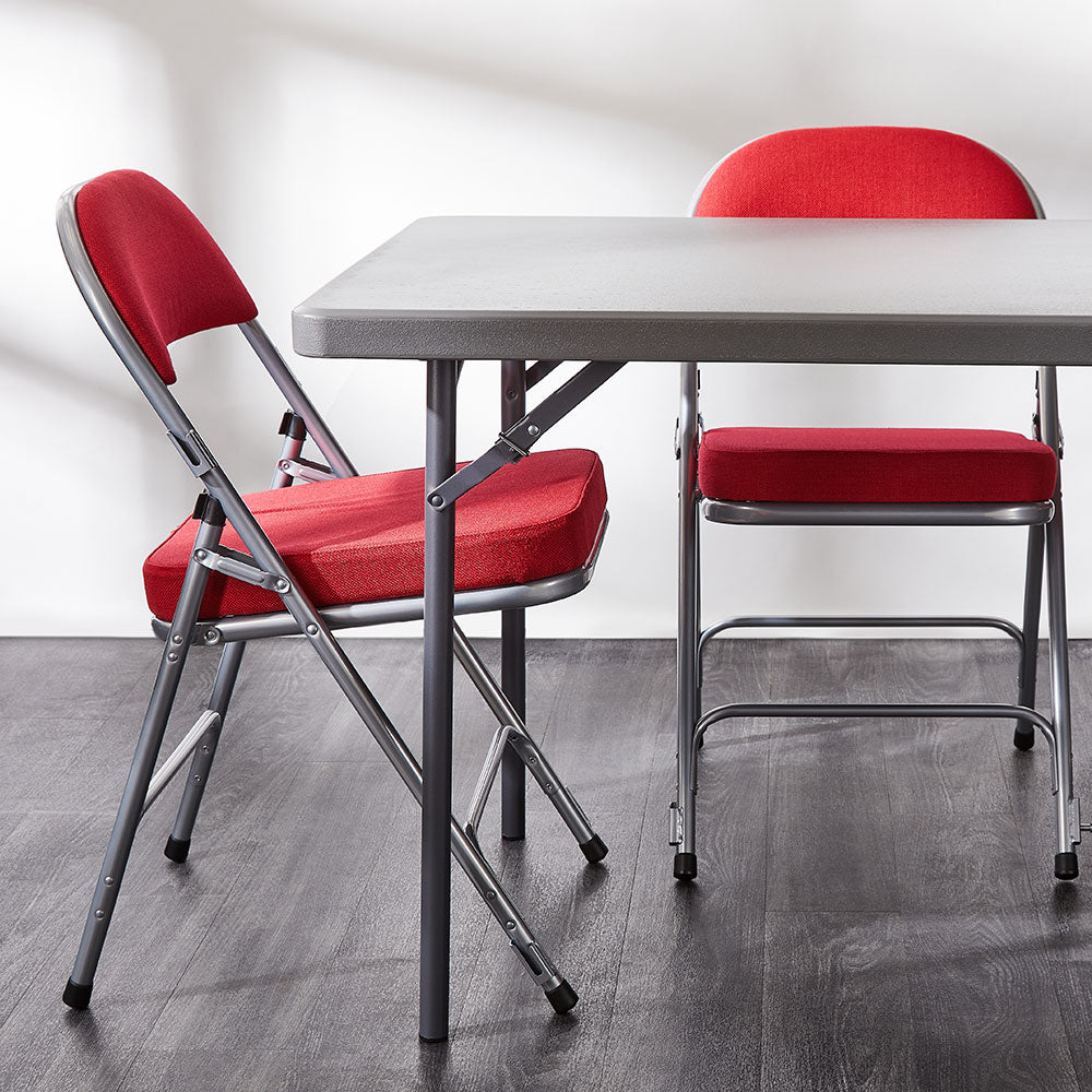 Red Comfort Deluxe padded folding chairs around a folding table.