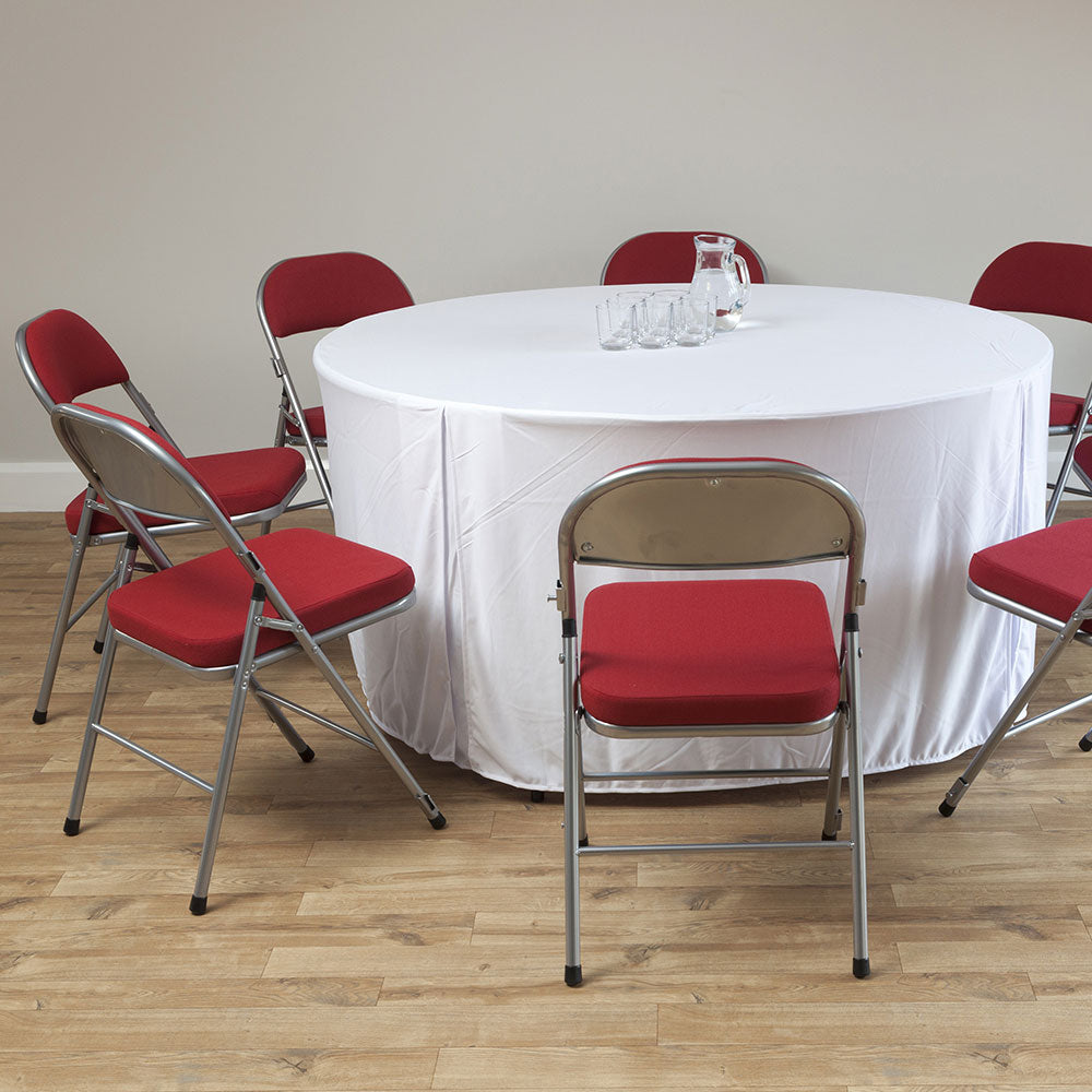 Red padded folding chairs set around a round banqueting table.